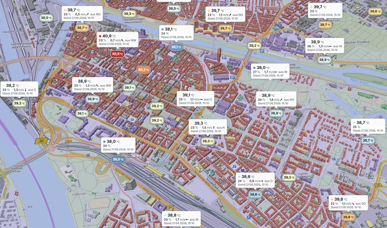 Mannheimer Innenstadt im 3D-Stadtmodell mit den Stationen des Stadtklimamessnetzes: An jeder Station ein Kärtchen mit Lufttemperatur, Luftfeuchte und Wind, Stand 27.06.2026, 15:10 Uhr; gemessen werden rund 38 bis 41 °C.